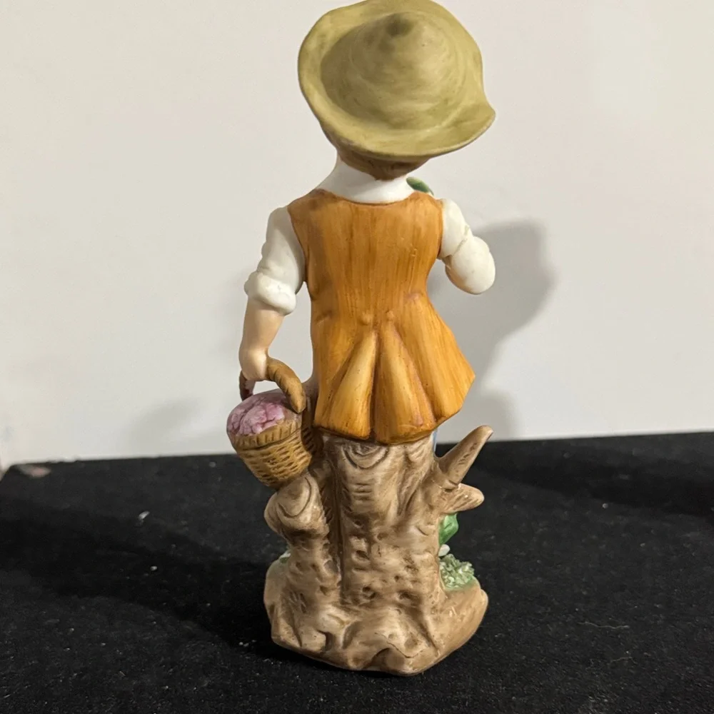 vintage hand-painted porcelain figurines of a boy and girl carrying baskets.